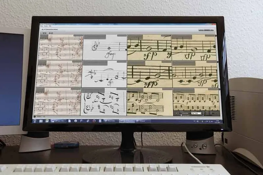 Digital tools are also used in the edition: Excerpts of sheet music from various manuscript and printed sources appear on a computer screen.